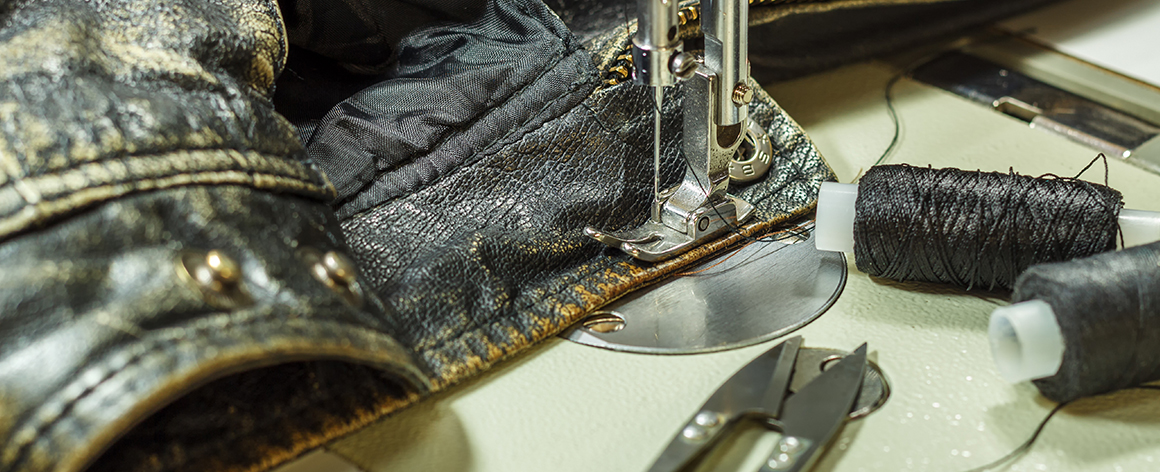 a worn leather jacket having a seam sewn with a sewing machine